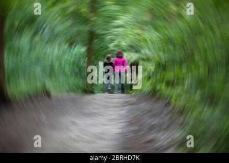 Una foto circolare sfocata di due ragazze che camminano sul sentiero della foresta Foto Stock