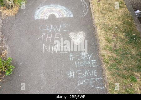 Londra, Regno Unito - 27 aprile 2020: Grazie nota a NHS, arcobaleno, e consigli per rimanere a casa, disegnato da bambino sul marciapiede pedonale a Lewisham d Foto Stock