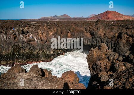 Primo piano sulla popolare attrazione turistica di Lanzarote, "Los Hervideros", le scogliere a forma di curiosità e le grotte subacquee formate da lava solidificat Foto Stock