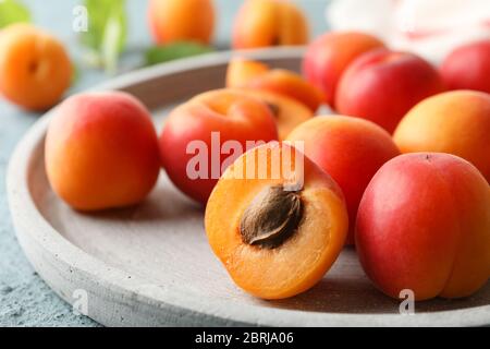 Composizione con vassoio di albicocche su fondo cementizio Foto Stock