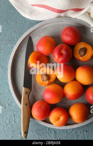 Composizione con vassoio di albicocche su fondo cementizio Foto Stock