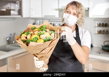 Ritratto di una giovane donna che impacchette il bouquet di frutta in carta da imballaggio. Foto Stock