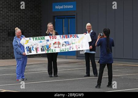 Il personale della NHS si riunisce fuori dall'Aintree University Hospital di Fazakerley, Liverpool, in vista degli applausi per salutare gli eroi locali durante l'iniziativa di giovedì del Nationwide Clap for Carers per riconoscere e sostenere i lavoratori e gli assistenti della NHS che combattono la pandemia del coronavirus. Foto Stock