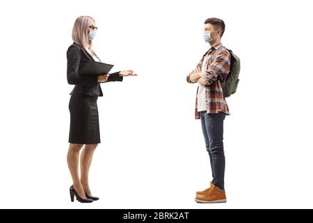Foto di profilo a lunghezza intera di una donna d'affari e uno studente maschile indossando una maschera protettiva e parlando isolato su sfondo bianco Foto Stock