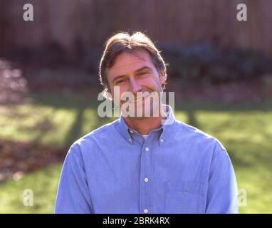 Uomo sorridente in giardino, Ascot, Berkshire, Inghilterra, Regno Unito Foto Stock