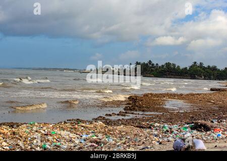 Inquinamento marino: Rifiuti scaricati nel Mar dello Sri Lanka vicino a Colombo. Le donne raccolgono oggetti di plastica in un mucchio di rifiuti portati dal surf dal mare Foto Stock