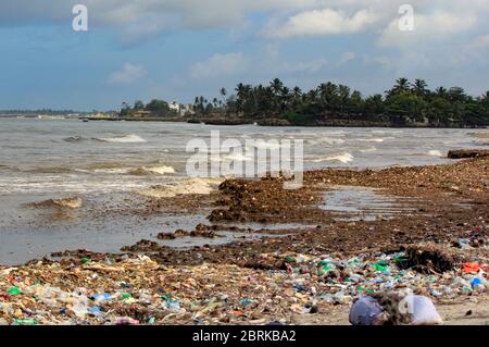 Inquinamento marino: Rifiuti scaricati nel Mar dello Sri Lanka vicino a Colombo. Le donne raccolgono oggetti di plastica in un mucchio di rifiuti portati dal surf dal mare Foto Stock