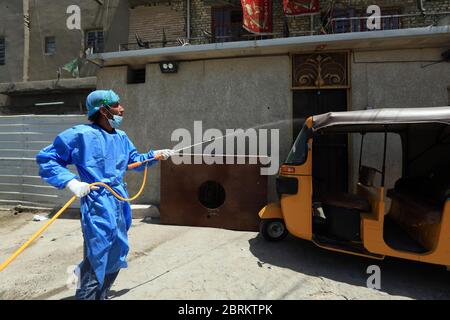 Baghdad, Iraq. 21 Maggio 2020. Un operatore medico disinfetta un risciò auto nel distretto di Sadr City a Baghdad, Iraq, il 21 maggio 2020. Il Ministero della Salute iracheno di giovedì ha registrato 153 nuovi casi di COVID-19, il più alto aumento giornaliero finora, portando il numero totale di infezioni a 3,877 nel paese. Credit: Khalil Dawood/Xinhua/Alamy Live News Foto Stock