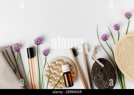 Spugne per viso e corpo, spazzolini da denti in bambù, profumo e pomice su sfondo bianco. Concetto di routine quotidiana. Foto Stock