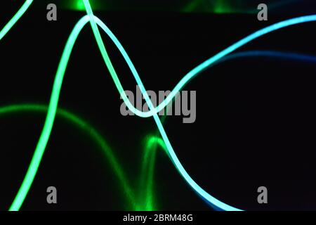 Filo luminoso verde e blu, un filo guida della luce con trasmissione della luce, spettro luminoso ed effetti luminosi diversi, situato in uno stato caotico. Foto Stock