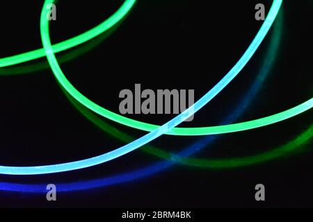 Filo luminoso verde e blu, un filo guida della luce con trasmissione della luce, spettro luminoso ed effetti luminosi diversi, situato in uno stato caotico. Foto Stock