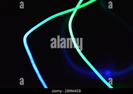 Filo luminoso verde e blu, un filo guida della luce con trasmissione della luce, spettro luminoso ed effetti luminosi diversi, situato in uno stato caotico. Foto Stock