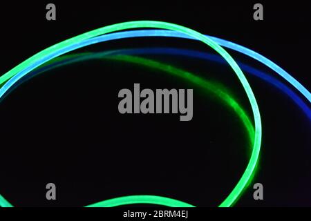 Filo luminoso verde e blu, un filo guida della luce con trasmissione della luce, spettro luminoso ed effetti luminosi diversi, situato in uno stato caotico. Foto Stock