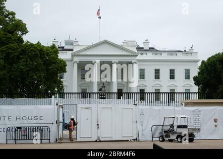 Washington, Stati Uniti. 21 Maggio 2020. Un lavoratore trasporta i materiali in un'area recintata fuori di costruzione su Pennsylvania Avenue, parte di un progetto di restauro che aggiorna la recinzione della Casa Bianca, a Washington, DC, il 21 maggio 2020 in mezzo alla pandemia di Coronavirus. Questa settimana, il numero di morti confermato negli Stati Uniti da COVID-19 è stato di 100,000, mentre molti stati spingono a riaprire le loro economie nonostante non soddisfare i requisiti raccomandati da esperti di sanità pubblica per una riapertura sicura. (Graeme Sloan/Sipa USA) Credit: Sipa USA/Alamy Live News Foto Stock