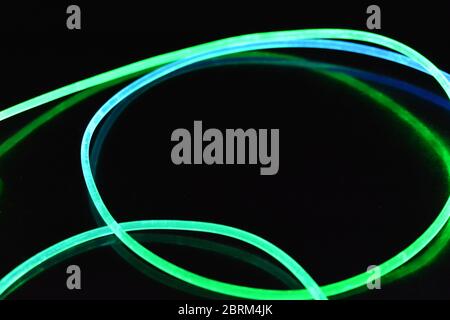 Filo luminoso verde e blu, un filo guida della luce con trasmissione della luce, spettro luminoso ed effetti luminosi diversi, situato in uno stato caotico. Foto Stock
