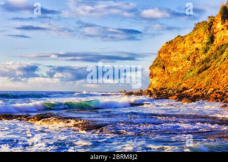 Ripide scogliere di Mona vale punta dalla spiaggia di Birubi in soffusa luce del sole del mattino. Foto Stock