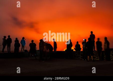 La gente al museo di Thomas A. Jaggar si affaccia nel Parco Nazionale dei Vulcani, Hawaii, USA guardando il lago di lava nella Caldera di Kilauea mentre si illumina t Foto Stock