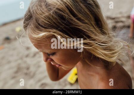 Ragazzino con capelli lunghi e ciglia scura e abbronzatura Foto Stock