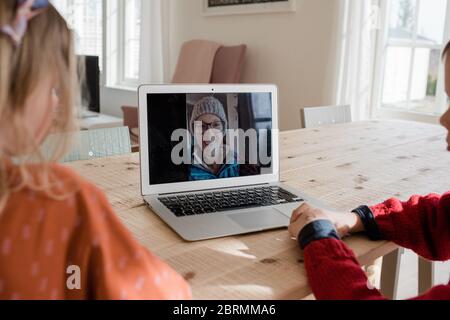 i bambini che hanno una videochiamata con la famiglia mentre si isolano a. casa Foto Stock