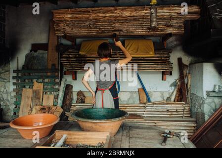 Donna in piedi in un laboratorio di Falegnameria che conta pezzi di legno Foto Stock