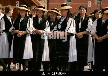 Festa popolare a Gura Raului, SB, Romania: Sarbatosarea Portului popolare. Donne che indossano costumi e cappelli tradizionali. Foto Stock