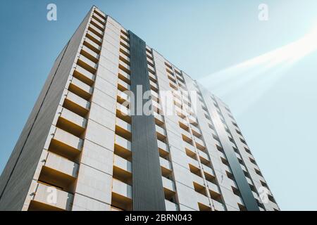 La facciata pulita di un edificio abbandonato con finestre rotte durante il giorno, con linee semplici. Foto Stock