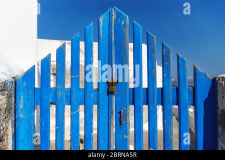 Tipico recinto greco di legno blu a forma di triangolo chiuso con serratura, Oia, Santorini, Grecia Foto Stock