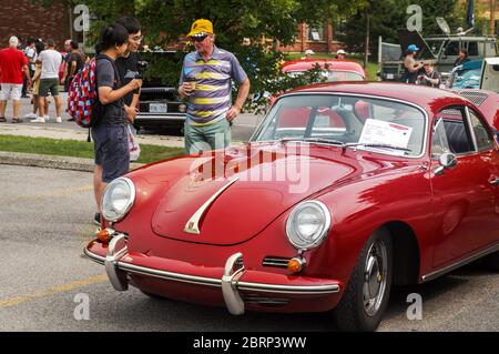 TORONTO, CANADA - 08 18 2018: Visitatori del programma auto all'aperto 'Wheels on the Danforth' che parlano con il proprietario accanto alla sua auto d'epoca - 1965 Foto Stock