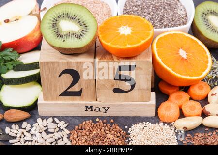 Calendario cubo con data del giorno Mondiale della tiroide e il miglior cibo contenente minerali naturali e vitamine per la tiroide sana Foto Stock