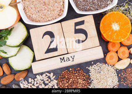 Calendario cubo con data del giorno Mondiale della tiroide e il miglior cibo contenente minerali naturali e vitamine per la tiroide sana Foto Stock