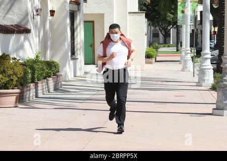 San Gabriel, California, Stati Uniti. 20 Maggio 2020. L'ospite della TV Joey Zhou corre con la sua maschera come parte del suo 'programma di idoneità pandemico' per aiutare gli altri ad ottenere l'esercitazione mentre si rimane al sicuro durante la pandemia di Covid-19 al Playhouse della missione di San Gabriel a San Gabriel, California. Il San Gabriel Mission Playhouse è stato costruito nel 1927 ed è un luogo storico per le arti dello spettacolo. Credito: Sheri Determan Foto Stock