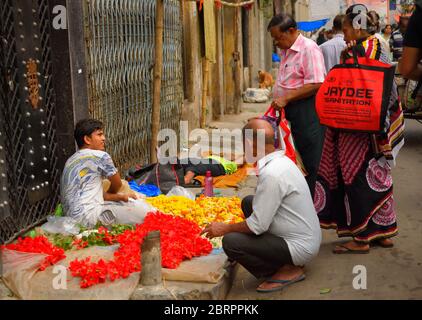 La gente che compra i fiori da un fornitore di strada. Foto Stock