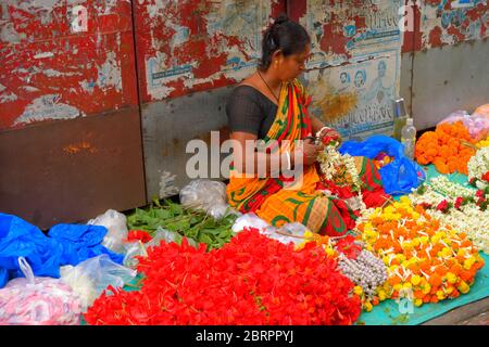 Una donna che vende fiori sul ciglio della strada. Foto Stock