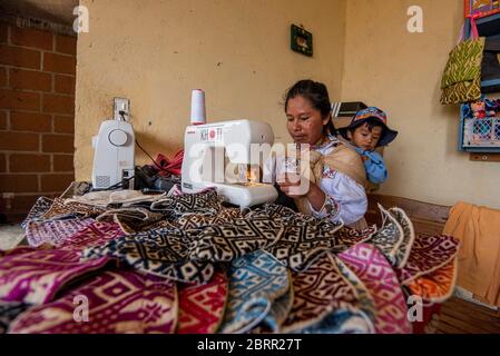 28 aprile 2020, Amealco, Messico: Un lavoratore fa maschere facciali riutilizzabili nel proprio ufficio durante la crisi del coronavirus.circa 20 donne Otomi della comunità di San Idelfonso, nel comune di Amealco Qro, hanno cambiato la direzione della loro attività in faccia della pandemia del Covid-19, Prima di questo erano dedicati a fare tovaglioli e bambole artigianali e ora, a causa della crisi del Coronavirus, la loro direzione è cambiata in fare le coperture artigianali della bocca, il tutto con il tema che le rappresenta come popolo indigeno dello stato. (Immagine di credito: © Jair Villeda/SOPA immagini via ZUMA Wire) Foto Stock