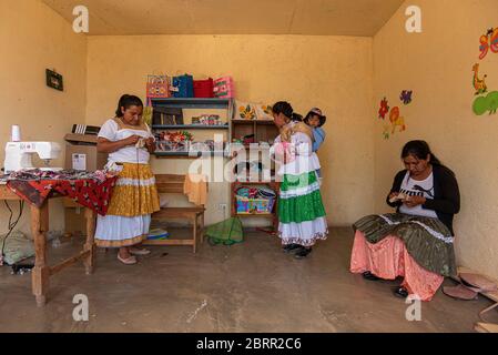 Amealco, Messico. 28 Apr 2020. I lavoratori fanno maschere facciali riutilizzabili nel loro ufficio durante la crisi del coronavirus.circa 20 donne di Otomi della comunità di San Idelfonso, nel comune di Amealco Qro, hanno cambiato la direzione del loro business in fronte alla pandemia del Covid-19, Prima di questo erano dedicati a fare tovaglioli e bambole artigianali e ora, a causa della crisi del Coronavirus, la loro direzione è cambiata in fare le coperture artigianali della bocca, il tutto con il tema che le rappresenta come popolo indigeno dello stato. Credit: Jair Villeda/SOPA Images/ZUMA Wire/Alamy Live News Foto Stock