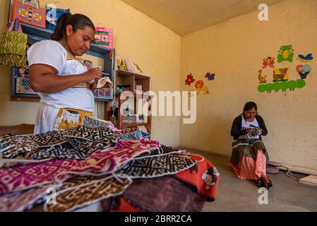 Amealco, Messico. 28 Apr 2020. I lavoratori fanno maschere facciali riutilizzabili nel loro ufficio durante la crisi del coronavirus.circa 20 donne di Otomi della comunità di San Idelfonso, nel comune di Amealco Qro, hanno cambiato la direzione del loro business in fronte alla pandemia del Covid-19, Prima di questo erano dedicati a fare tovaglioli e bambole artigianali e ora, a causa della crisi del Coronavirus, la loro direzione è cambiata in fare le coperture artigianali della bocca, il tutto con il tema che le rappresenta come popolo indigeno dello stato. Credit: Jair Villeda/SOPA Images/ZUMA Wire/Alamy Live News Foto Stock