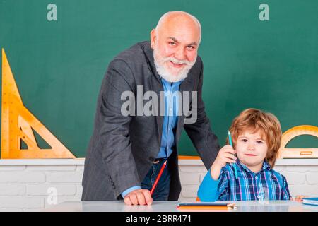 Ritratto di nonno e Figlio in classe. Padre e figlio - generazione di persone concetto. Uomo con insegnante anziano che impara in classe su sfondo a colori Foto Stock