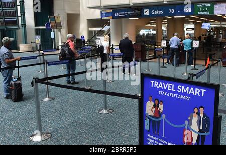 Orlando, Stati Uniti. 21 Maggio 2020. Un cartello che ricorda ai passeggeri di rimanere a una distanza di circa 6 metri è visibile presso un punto di controllo all'aeroporto internazionale di Orlando. L'Amministrazione per la sicurezza dei trasporti ha introdotto nuove linee guida per lo screening dei passeggeri aerei, volte a ridurre le possibilità che i suoi ufficiali siano esposti al coronavirus. Le nuove regole, che entrano in vigore a metà giugno a livello nazionale, includono l'obbligo per i passeggeri di effettuare la scansione delle proprie carte d'imbarco, insieme a una raccomandazione di indossare maschere facciali. Credit: SOPA Images Limited/Alamy Live News Foto Stock