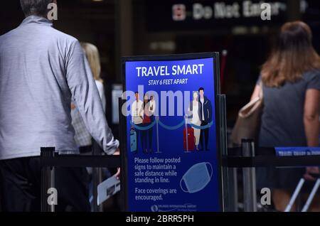 Orlando, Stati Uniti. 21 Maggio 2020. Un cartello che ricorda ai passeggeri di rimanere a una distanza di circa 6 metri è visibile presso un punto di controllo all'aeroporto internazionale di Orlando. L'Amministrazione per la sicurezza dei trasporti ha introdotto nuove linee guida per lo screening dei passeggeri aerei, volte a ridurre le possibilità che i suoi ufficiali siano esposti al coronavirus. Le nuove regole, che entrano in vigore a metà giugno a livello nazionale, includono l'obbligo per i passeggeri di effettuare la scansione delle proprie carte d'imbarco, insieme a una raccomandazione di indossare maschere facciali. Credit: SOPA Images Limited/Alamy Live News Foto Stock