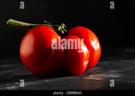 Frutta o verdura brutta. Pomodoro mutante gravemente malformato. I negozi di alimentari preferiscono soprattutto frutta e verdura di qualità migliore. La frutta brutta non è in alta d Foto Stock