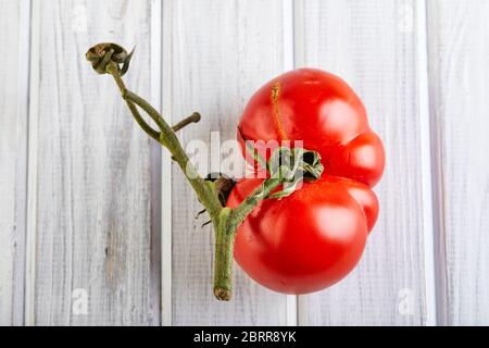 Frutta o verdura brutta. Pomodoro mutante gravemente malformato. I negozi di alimentari preferiscono soprattutto frutta e verdura di qualità migliore. La frutta brutta non è in alta d Foto Stock