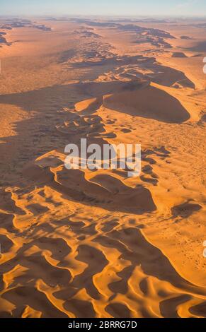 Immagine verticale delle splendide e suggestive dune di sabbia del deserto del Namib a Sossusvlei, Namibia, sparate da un elicottero al tramonto. Foto Stock