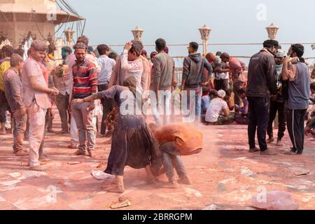 La gente celebra il tradizionale e un ritualistico colorato Lathmar Holi con danza e volti colorati al tempio Radharani a Barasana, Uttar Pradesh Foto Stock