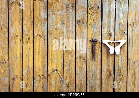 Scarpe da sposa beige e martello alla parete di legno giallo con vernice fessurata Foto Stock