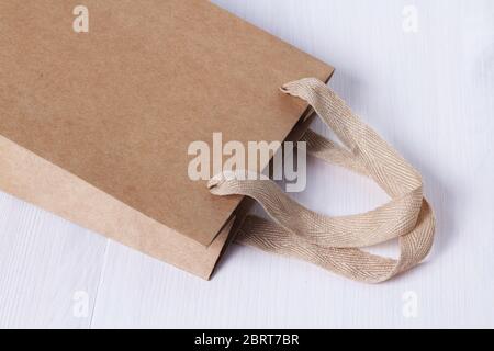 Modello di imballaggio. Manico in materiali naturali. Parte della confezione. Sacchetto di carta da asporto monouso per piccoli oggetti da asporto su un tavolo bianco nel Foto Stock