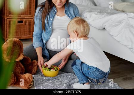 La donna incinta e il suo piccolo figlio Foto Stock