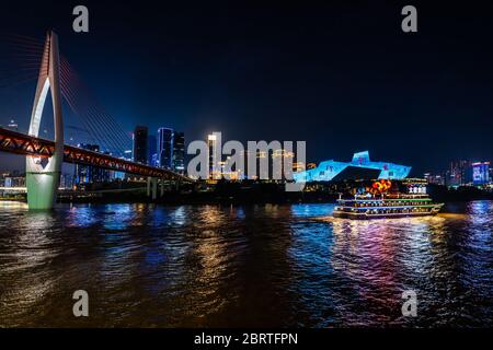 Chongqing, Cina - Agosto 2019 : lussuosa nave turistica passeggeri che naviga sotto il ponte illuminato DongShuiMen su e attraverso la possente Rive Yangtze Foto Stock