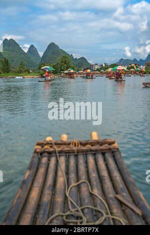 Yangshuo, Cina - Agosto 2019 : primo piano di zattera di bambù per il trasporto di turisti guidato da guide sul panoramico e bel fiume Yulong Foto Stock