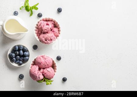 Gelato al mirtillo in ciotole su sfondo bianco. Spazio per il testo. Vista dall'alto. Foto Stock