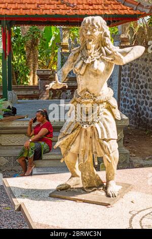 BALI, INDONESIA - 30 novembre 2019: Donna janitor che parla per telefono nel Palazzo dell'acqua di Tirta Gangga. Balinesi. Bali Est, Indonesia Foto Stock